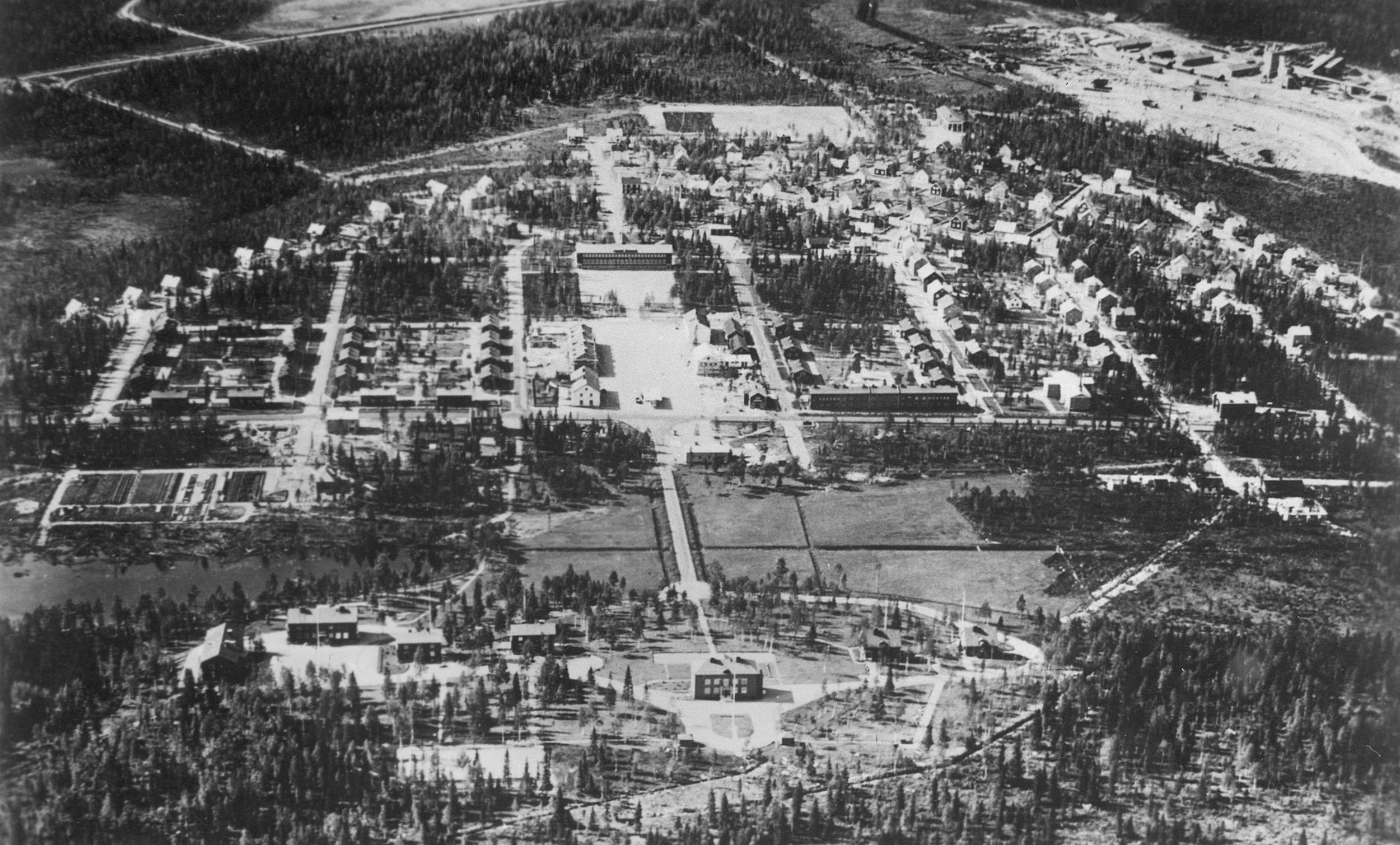 Flygfoto från öster på 1930-talet, med disponentbostaden närmast, och det halvcirkel-formade samhället som breder ut sig mot väster. Foto: Skellefteå museum. SM BOL 4286