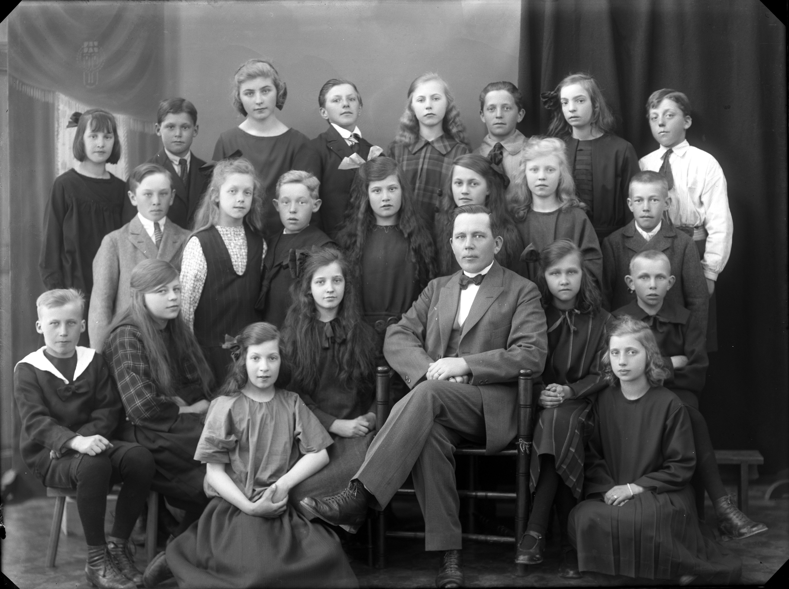 Skolklass vid folkskolan på Brännan. Stående tredje från vänster i bakre raden lärarinnan Anna Stenberg och sittande läraren Carl Olov Hedström. Fotot taget 1924.