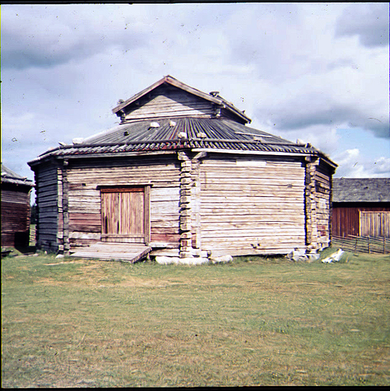 En rundloge med vedtak och kornbod på taket på Burträsks hembygdsområde. Foto: Hans Christiansson, Skellefteå museum. SM DIA 13183.